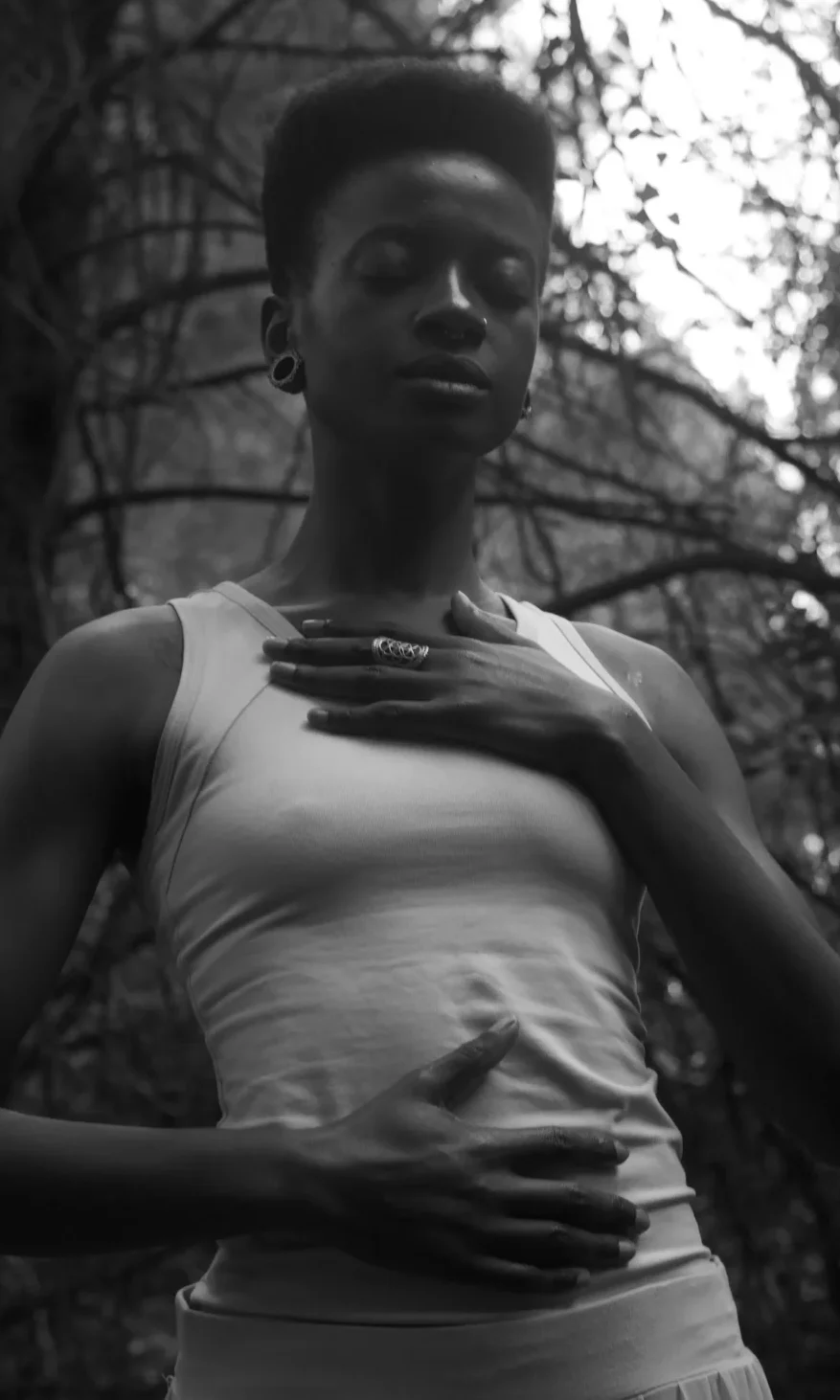woman holding her chest and stomach and engaging in breathwork.